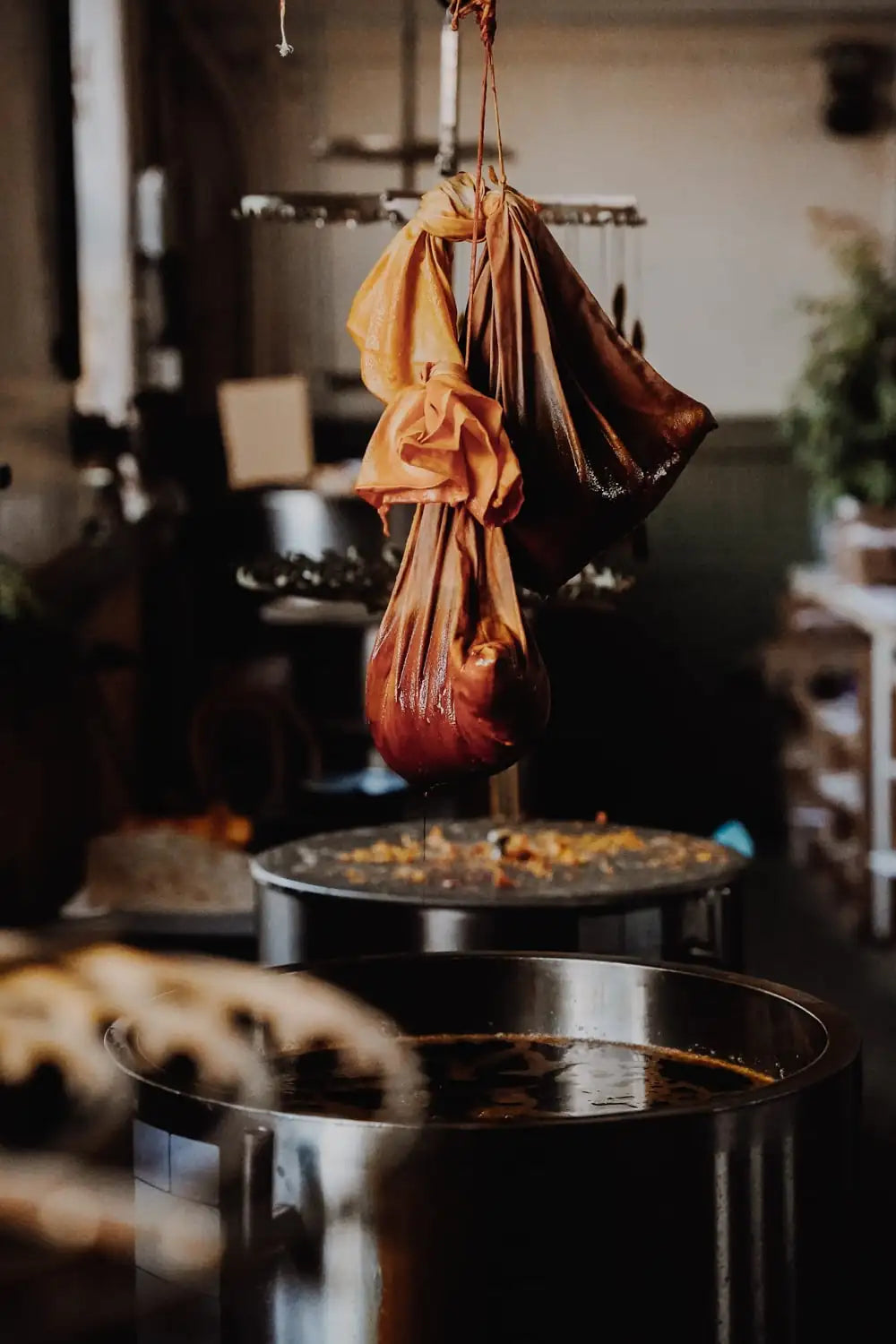Organic Paprika dye bag hanging above molten wax 